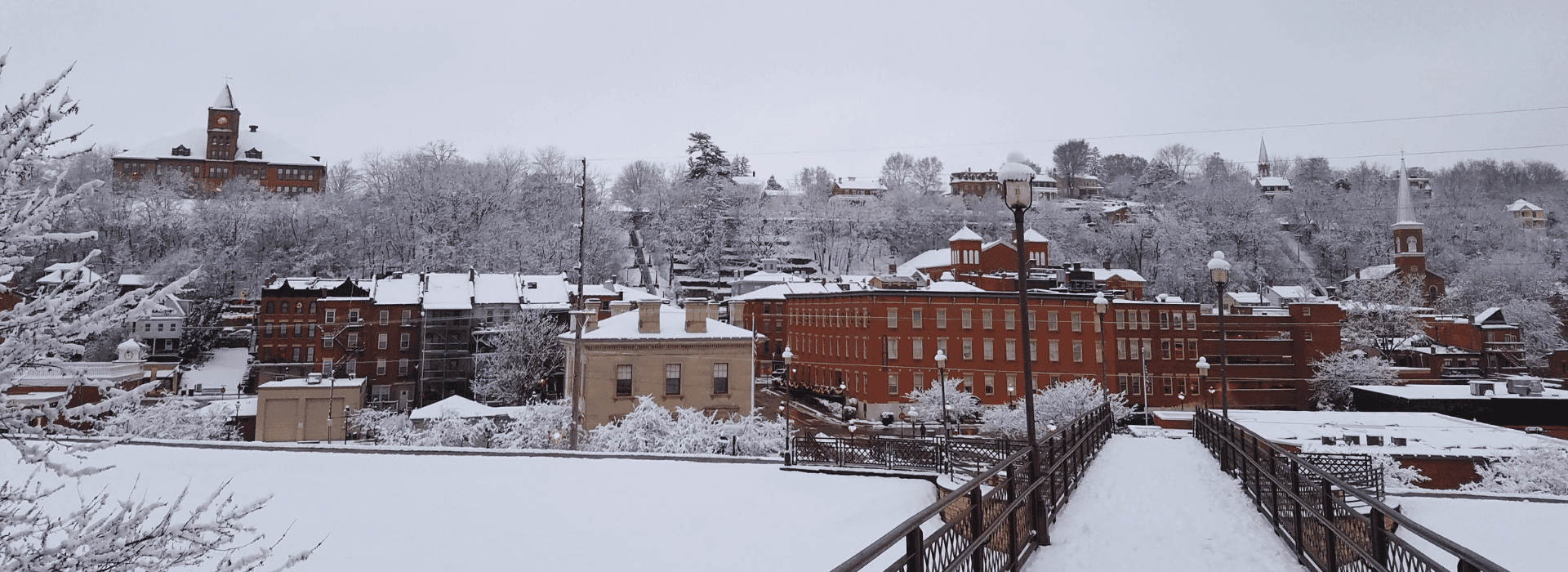 A snowy landscape featuring historical buildings and trees blanketed in white. A snowy landscape featuring historical buildings and trees blanketed in white.