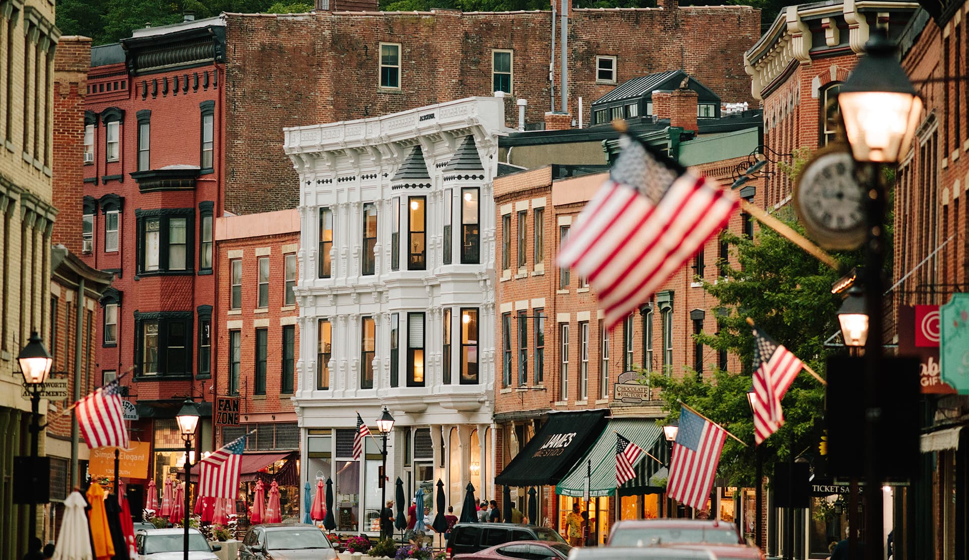 A scenic downtown street lined with historic buildings and American flags.