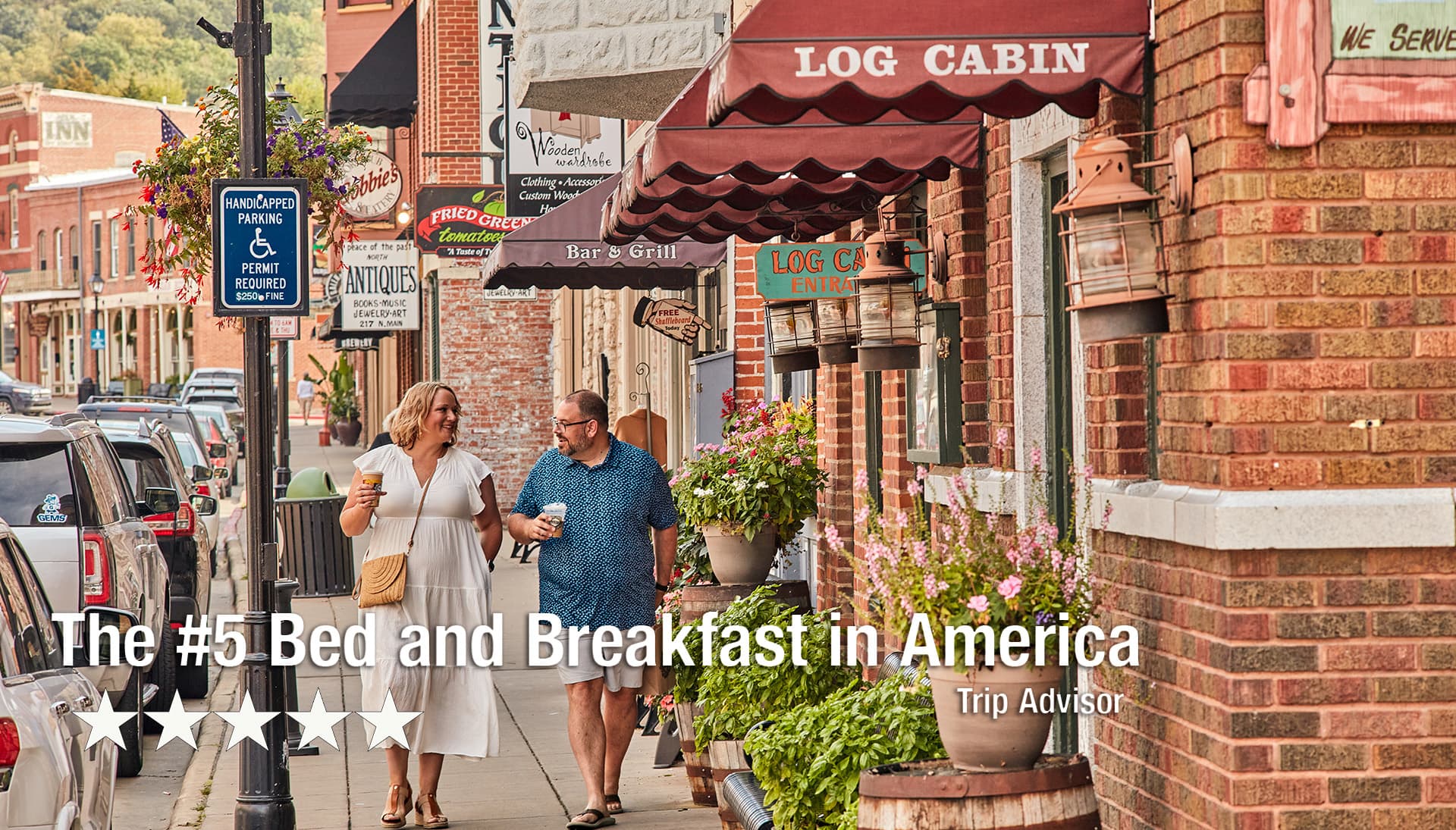 Two people stroll down a charming street lined with shops and flowers.
