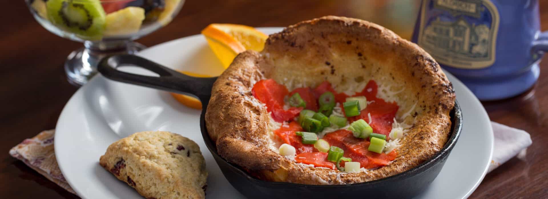 Photo of a Dutch Baby in a skillet with salmon and chives